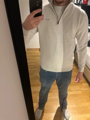 Ljusgrå half zip tröja Bondelid M - Säljer en ljusgrå tröja från Bondelid i storlek M. Tröjan har half zip-dragkedja, ribbade muddar och diskret broderad logga på bröstet. Materialet är mjukt och stickat, perfekt för lager på lager under höst och vinter.