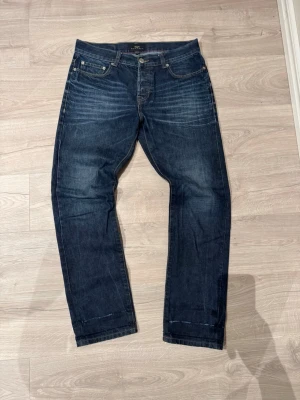 Farrell jeans - Snygga mörkblå jeans från Farrell med klassisk femficksdesign och kontrastsömmar. Jeansen har raka ben och subtila slitningar framtill för en cool look. Tillverkade i robust denim med läderpatch bak i midjan.