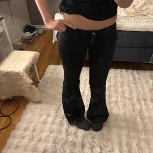 Svarta bootcut jeans från weekday  - Säljer ett par svarta jeans från weekday med bootcut-modell och låg midja. Jeansen har klassiska fickor fram och bak, samt en snygg detalj med Miss Sixty-logga på bakfickan. Materialet är stretchigt och sitter riktigt snyggt på benen.