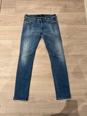 Replay Hyperflex  - Säljer ett par Replay Hyperflex jeans i klassisk blå tvätt med snygga slitningar och broderade bakfickor. Modellen är slim och har normal midja. Jeansen är stretchiga och riktigt sköna, perfekta till vardagslooken. Materialet är en mjuk jeansblandning.