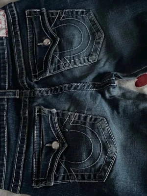 True Religion byxor med diamanter❤️ - Snygga true religon jeans med wash 84cm innerbenet 40cm rakt över vid midjan och 107 cm långa❤️ Säljer dom då dom inte kommer till användning men annars älskar jag dom. Dom är raka/bootcut men för det mesta raka. Dom har fina detaljer med diamanter som knappar och runt fickorna❤️ pris går att diskutera
