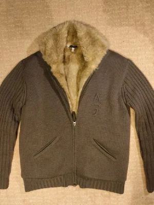 Vintage Armani Cardigan  - Säljer min Armani zip med päls då den är lite för kort. Jävligt snygg zip som passar för kallare dagar med snyggt broderad A J logga på bröstet. Tveka inte på att skriva om ni undrar något. Nypris över 7000kr