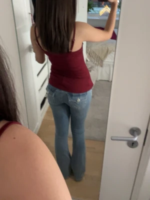 Ljusblå bootcut jeans låg midja - Säljer ett par ljusblå jeans med bootcut och låg midja. Jeansen har klassisk femficksdesign, snygga sömmar och är i ett mjukt denimtyg. Passformen är slim upptill och vidare nedtill för en riktigt snygg siluett.