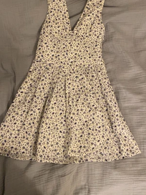 Blommig kortklänning  - Supersöt kortklänning med blå blommigt mönster. En gömd dragkedja på sidan.  //skriv om ni undrar om något 💕(läs min profil)