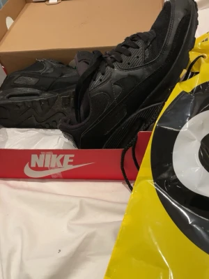 Svarta Nike Air Max sneakers - Säljer ett par helsvarta Nike Air Max sneakers med klassisk chunky sula och synlig Air-enhet. Skorna har mesh och skinnpaneler, snörning och diskret Nike-logga på sidan. Perfekta för dig som gillar streetwear lite slitna och smutsiga men går perfekt att tvätta av(: