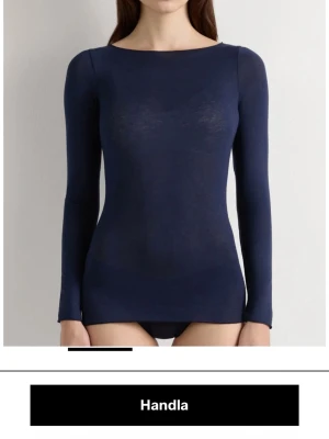 Mörkblå långärmad tröja Intimissimi - Superslimmad och ultralätt långärmad tröja från Intimissimi i mörkblått. Tröjan har en enkel, rund halsringning och är tillverkad i ett tunt, mjukt material som känns skönt mot huden. Perfekt att bära som lager eller för en clean look.