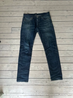 A.P.C. Raw selvadge denim jeans - Säljer ett par klassiska A.P.C. jeans i mörkblå denim. Modellen har raka ben, fem fickor och snygga slitningar. Tillverkade i 100% bomull för en schysst och hållbar känsla. Perfekta om du gillar stilrena och tidlösa jeans.
