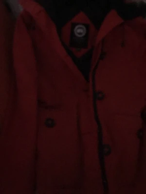 Röd dunjacka från Canada Goose - Säljer en röd dunjacka från Canada Goose med huva och stora knappar framtill. Jackan har klassisk parkamodell och är perfekt för kalla dagar. Tillverkad i Kanada och fylld med dun för extra värme. Snygg och funktionell design med fickor och justerbar huva.