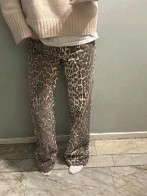 Leopardmönstrade jeans från NA-KD - Säljer ett par riktigt snygga leopardmönstrade jeans från NA-KD i storlek 34. Byxorna har rak passform och normal midja, med klassisk femficksdesign och knappgylf. Materialet är kraftigt och känns som bomull med lite stretch. Perfekta för dig som vill sticka ut!