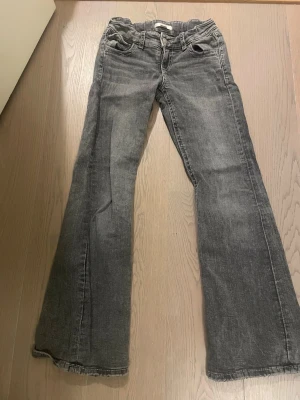 Grå bootcut jeans Gina Tricot 146 - Säljer ett par gråa bootcut jeans från Gina Tricot i storlek 146. Jeansen har snygga broderade detaljer på bakfickorna och klassisk femficksmodell. Materialet är jeans med en tvättad look och passformen är normal.