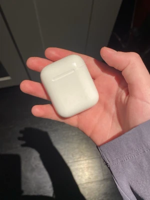 Apple AirPods - Säljer ett par Apple AirPods (2nd gen) med laddningsetui. Fungerar utmärkt och är i gott skick med endast mindre ytliga repor på etuiet. Perfekt för trådlös musik och samtal, kompatibla med iPhone och andra enheter.