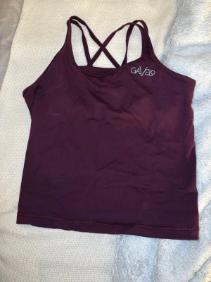 Lila träningstopp från Gavelo - Lila träningstopp från Gavelo med inbyggd bh. Toppen har tunna axelband som korsas i ryggen. Säljes tillsammans med leggings i tidigare annons eller separat. 
