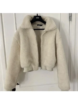 Beige teddyjacka - Supervarm och fluffig beige teddyjacka från Boohoo i storlek 38. Passar även storlek 36. Perfekt för dig som vill ha en cozy vibe i höst och vinter. Gåva vid köp!🎁