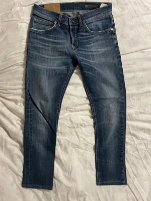 Dondup jeans - Säljer ett par klassiska blå dondup mius jeans med snygg tvätt och de sitter ungefär som Dondup george. Jeansen har fem fickor, detaljerade bakfickor och normal passform. Tillverkade i slitstarkt bomullsmaterial med subtila slitningar för en cool look. Ungefär 110cm långa.