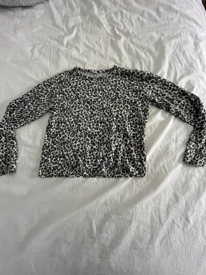 Leopardmönstrad långärmad topp Lindex - Säljer en långärmad topp från Lindex i storlek 146/152. Toppen har ett coolt leopardmönster i svart och vitt och är tillverkad i mjuk bomull. Perfekt för dig som vill sticka ut lite extra med ett djurmönster.