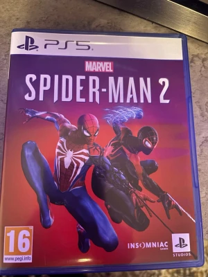 Marvel's Spider-Man 2 (PS5) - Marvel Spider-Man 2 Playstation 5-spel. Spelet levereras i originalfodral med skiva.   Säljer spelet eftersom jag spelat klart det och har ingen användning av det längre! Allt funkar som det ska, inga repor eller skador. Kan fraktas och pris går att diskutera!