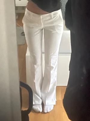 Vita bootcut kostymbyxor lågmidjade  - Säljer ett par vita kostymbyxor med låg midja och bootcut-snitt. Byxorna har en slits vid foten. Inga fläckar, som nya🩷 storlek xs, passar mig fint som är 170 lång