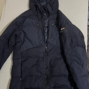 Svart  Sail Racing jacka  - Säljer en svart dunjacka från Sail Racing. Perfekt för kalla dagar och riktigt snygg. Har några skador. 