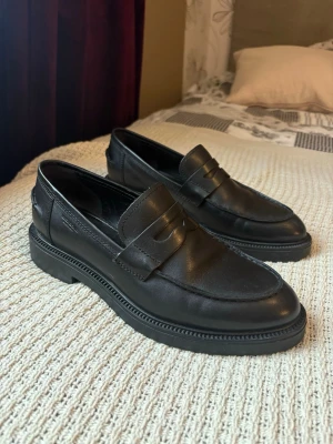 Svarta loafers från Vagabond, storlek 41 - Klassiska svarta loafers från Vagabond i storlek 41 (dam). Inlöptes för 1300 kr 2025, men endast använda fåtal gånger pga att de ej passar mig. Finns knappt tecken på användning. 