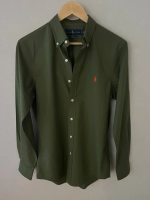 Ralph Lauren Skjorta - Helt Ny - Säljer en jättefräsch Ralph lauren skjorta i storlek S, modell Slim Fit och färgen grön/olivgrön då den inte passade! Helt nytt skick - 10/10, inte ens använd och endast testad. Vid minsta lilla fråga tveka inte på att höra av er! 😊