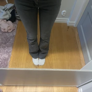 Mörkgrå bootcut jeans - Snygga mörkgrå jeans med bootcut passform och klassisk femficksdesign. Blixtdetalj på bakfickan ger en cool touch. Jeansen har hög midja och är tillverkade i ett mjukt jeansmaterial som sitter bekvämt och följer kroppen.