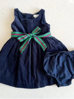 Ralph Lauren christmas dress 18 months - Väldigt fin och snygg klänning från Ralph Lauren storlek 18 månader, motsvarande 86. Medföljande shorts I samma färg. Textilen är en tjockare variant, corduroy. Klänning har en under-kjol för volym. Fina klassiska Ralph Lauren detaljer medi bandet och knapparna.   Använd 1-2 gånger. Felfritt skick.  Djur-och rökfritt hem  