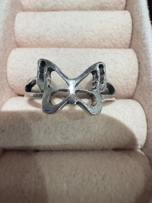 Silvrig ring med fjärilsdesign - Cool silvrig ring med en öppen fjärilsformad front. Ringen har en justerbar öppning baktill och en stilren, minimalistisk look som passar perfekt för att ge outfiten en extra touch. Fjärilen är ihålig och ger en lätt och luftig känsla.