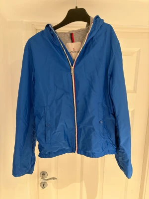Moncler vindjacka - En blå moncler vindjacka. Passar om man är ca 155-165cm lång. Mycket fint skick. Skriv vid minsta lilla intresse. Pris kan diskuteras vid snabb affär.