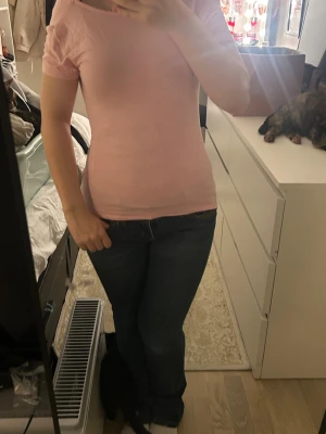 Ljusrosa topp med öppen rygg 157 - Säljer en ljusrosa topp från 157 i storlek S. Modellen är slim och har korta ärmar samt en snygg öppen rygg. Toppen är tillverkad i mjuk bomull och har en enkel, stilren design utan mönster eller detaljer. Perfekt för dig som gillar basic med en twist.