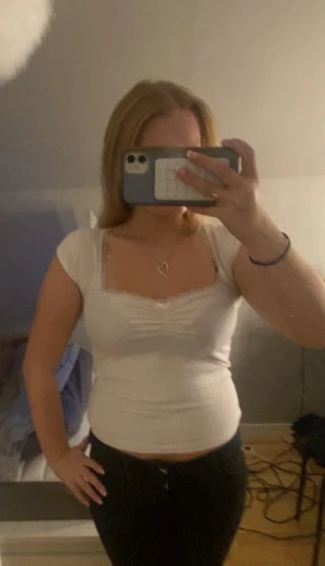 Vit topp - Säljer en vit topp med korta ärmar och söt spetskant vid urringningen. Toppen har rynkdetalj framtill. Perfekt för fest🤩