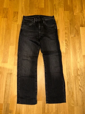 Svarta jeans från Acne Studios - Snygga svarta jeans från Acne Studios med klassisk femficksdesign och raka ben. Jeansen är tillverkade i 100% bomull och har en mörk tvätt med subtila slitningar. Perfekt för dig som gillar stilrena och tidlösa plagg med streetkänsla.