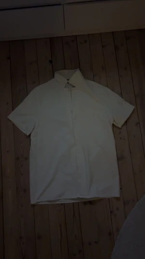 Vit kortärmad skjorta  - En riktigt snygg kortärmad skjorta från Shein. Funkar väldigt bra under sommaren och matchar med allt tänkbart. Man kan inte tro att den är från Shein på grund av sin goda kvalitet och hållbarhet. Nypris 150kr. Tveka inte att höra av dig vid intresse eller möjliga frågor! Pris kan diskuteras!