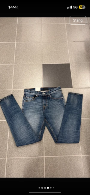 Blå tiger of sweden  jeans W28 L32 - Snygga blå jeans med slim fit och klassisk femficksdesign. Jeansen har orangea sömmar, rak passform och är tillverkade i slitstarkt denim. Perfekt för dig som gillar en smalare siluett och vill ha en tidlös look.