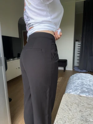 Svarta kostymbyxor från Lager157, storlek S - Säljer ett par svarta kostymbyxor med hög midja och vida ben. Byxorna har pressveck framtill, diskreta fickor i sidorna och en snygg, stilren look. - Köper du innan kl 16:00 kan jag posta samma dag!