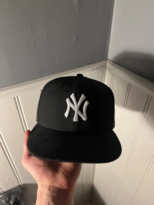 New era 59fifty NY keps - Säljer min new era keps som är använd typ 2ggr eftersom den inte riktigt är min stil och har därmed inga defekter eller tecken på användning alls . Den är svart och i storlek 7 3/8, vilket är 58,7cm. Har böjt till skärmen litegrann så den får en schysstare passform men om du diggar platt skärm mer så går det böja tillbaka👍 Nypris ligger på 500kr, säljer för 375!