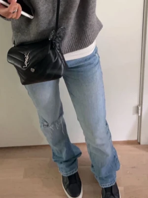  ljusblå jeans med hål - Ljusblå  jeans med klassisk femficksdesign och rakt ben. Jeansen har ett snyggt hål på ena knät för en avslappnad vibe. Tillverkade i bomull med normal passform och låg midja. Perfekta för dig som gillar en tidlös och cool look. Lite slitna längst ner. Passar mig som är 172. Innebenslängd ca 84 
