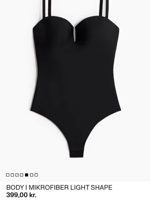 Söker!!!!! Strl M - Snygg svart body med smala axelband och formande passform. Tillverkad i mjuk mikrofiber som sitter tight mot kroppen. Stilren och enkel design med lätt v-ringad urringning framtill. Perfekt att styla med jeans eller kjol för en clean look.