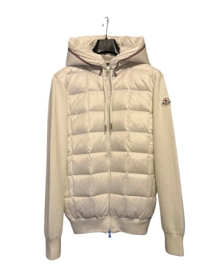 moncler cardigan ( L) (XL) -  En vit moncler cardigan, I storlek xl passar bättre dig som bär L eftersom cardigan är normalt mindre i storleken. Jackan har använts en gång innan Och är därför i jättebra skick. För fler bilder eller frågor är det bara att höra av dig.