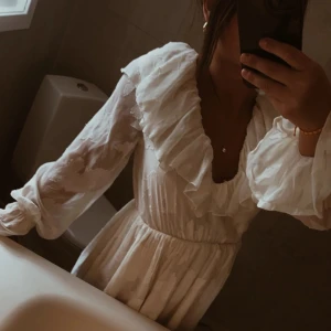 Vit blommig volang klänning  - Hej! Säljer denna super söta vita klänning ifrån Bohoo som inte längre säljs där! Helt ny, lapp kvar, säljes då jag tänkte ha den till ett event men det blev inte av. Kan användas till alla sorters bruk, så fin! Storlek S/36. Passar såklart XS/M oxå.