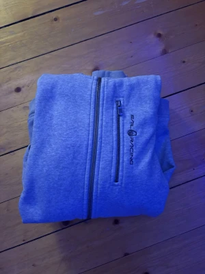 Grå hoodie från Sail Racing - Kan inte visa på då den är för liten för mig. Har använt många gånger men den är som nytt skick, inga fläckar eller hål. Pass storleken är sann till storleken! 