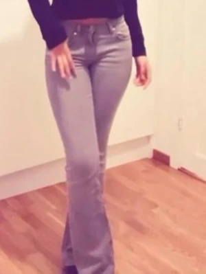 Grå bootcut jeans - mid waist - Snygga grå bootcut jeans med en medel midja. Jeansen har utsvängda ben, perfekta för en trendig och avslappnad look. Tillverkade i mjukt denimtyg som ger en bekväm känsla hela dagen.