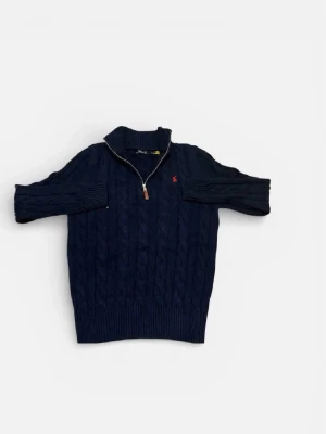 Mörkblå kabelstickad tröja Polo Ralph Lauren - Mörkblå kabelstickad tröja från Polo Ralph Lauren med halv dragkedja och hög krage. Tröjan har ett rött broderat logomärke på bröstet och ribbade muddar vid ärmslut och nederkant. Perfekt för lager på lager och klassisk stil.