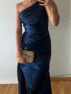 Marinblå one shoulder balklänning - Säljer min balklänning, köp från en hemsida i Albanien. Använd en gång och skräddarsydd i midjan för en finare passform. Väskan på bilderna går att köpa till, finns fler bilder vid intresse❤️