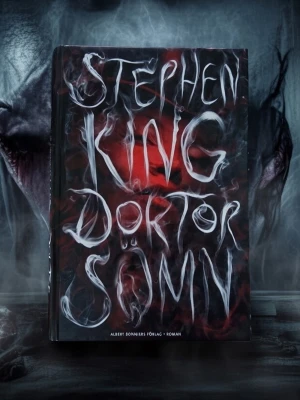 Doktor Sömn av Stephen King - Säljer boken 'Doktor Sömn' av Stephen King, utgiven av Albert Bonniers Förlag. Omslaget är svart med vit och röd rökig text och motiv. Boken är en roman och uppföljare till The Shining. Perfekt för dig som gillar spänning och skräck.