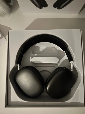 Svarta Apple AirPods Max hörlurar - Säljer ett par stilrena svarta Apple AirPods Max over-ear hörlurar. De har en modern design med aluminiumkåpor, mjuka öronkuddar och justerbart huvudband i mesh. Perfekta för dig som vill ha grymt ljud och snygg look.