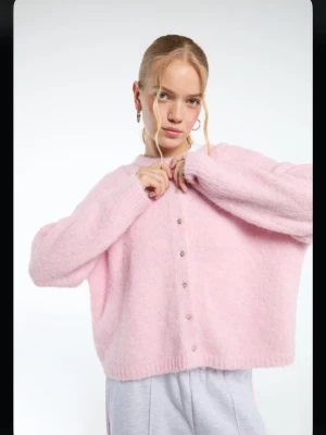 Ljusrosa fluffig kofta med knappar - Mysig ljusrosa kofta med fluffig känsla och pärlemorknappar framtill. Koftan har lång ärm och en avslappnad passform, perfekt att slänga på sig över en t-shirt. Enkel och stilren design utan synligt märke. Knapparna har varit så sedan jag köpte de. Använt en gång för spex foto i skolan.