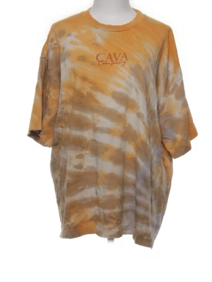 Gul och grå tie-dye t-shirt AVA - Säljer en oversized t-shirt från AVA Company med grått och gult tie-dye mönster. T-shirten har korta ärmar, rund halsringning och tryckt logga på bröstet. Perfekt för dig som gillar en avslappnad och trendig stil.