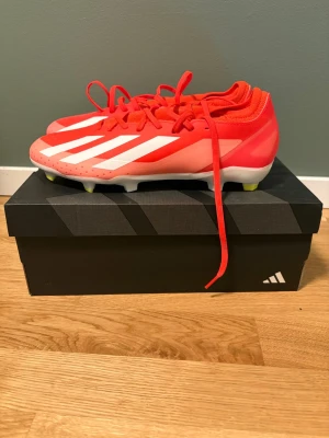 Adidas Crazyfast röda fotbollsskor - Säljer ett par Adidas Crazyfast fotbollsskor i rött med vita detaljer och gula dobbar. Som nya har knappast använt dom