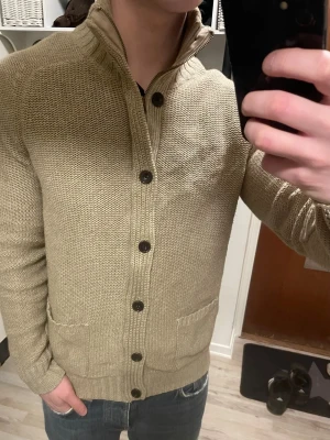 Beige stickad cardigan - Otroligt snygg beige stickad cardigan. Passar perfekt till kallare väder. Modellen är 180cm, 75kg. Priset kan såklart diskuteras!
