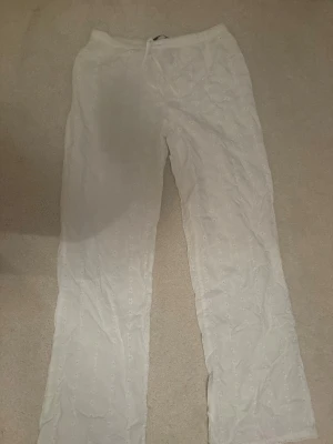 Vita linnebyxor med broderade detaljer - Vita byxor från Bikbok i ett blommig mönster, aldrig använda💕